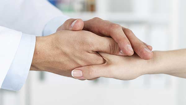 Image of Doctor holding patients hand
